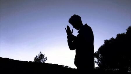 Miracle Prayer Code Review: Access Divine Abundance Today a silhouette of a man praying in the evening